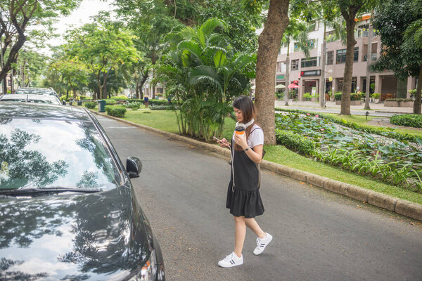 Young girl using phone while crossing the street