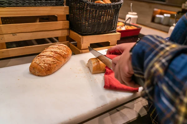 キッチンでパンを切る女の手 — ストック写真