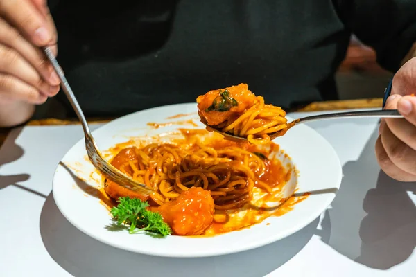 Самки едят спагетти вручную — стоковое фото
