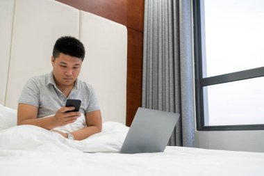 Genç adam akıllı telefondan e-postaları kontrol ediyor.