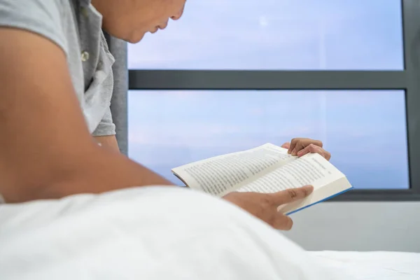 Egy férfi könyveket olvas a hotelszobájában. — Stock Fotó