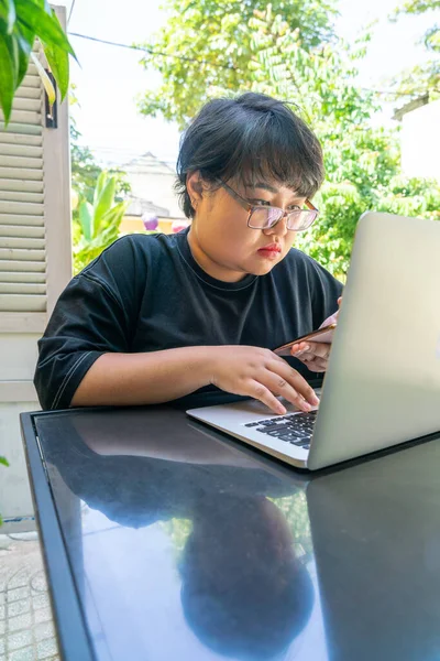 Chica asiática usando el ordenador portátil y smartphone — Foto de Stock