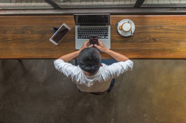 Akıllı telefon, laptop ve tablet kullanan bir işadamı