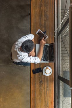 Tablet ve laptop kullanan Asyalı işadamı