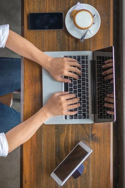 Mänskliga händer skriva laptop på café — Stockfoto