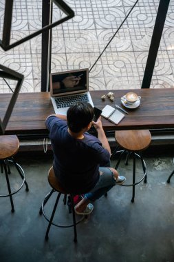 Kısa saçlı lezbiyen kadın akıllı telefon kullanıyor.