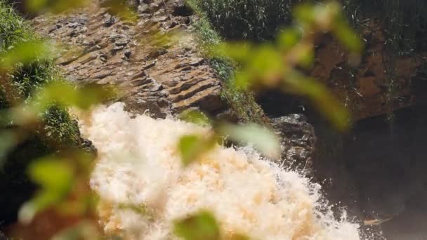 Een uitzicht op sterke waterval plons stroomt in slow motion het creëren van mist en spray. — Stockvideo