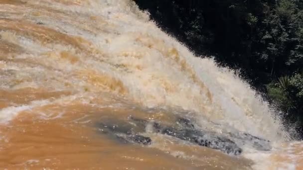 Close-up zicht op dynamische stroom van enorme waterval met oranje water. — Stockvideo
