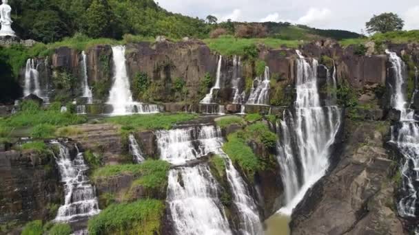 Cinematic antenn av natursköna vattenfall i Asien i tropisk djungel med dam buddha — Stockvideo