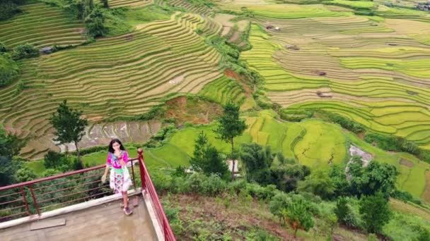 Luchtfoto van een speels meisje in Hmong jurk met prachtige rijst terrassen landschap. — Stockvideo