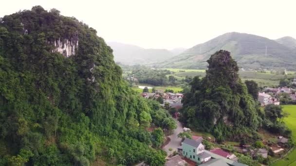 Aerial of picturesque countryside village with cliffs covered of lush greenery. — Stock Video