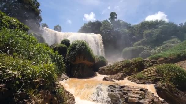 Toller Blick auf den riesigen Wasserfall im exotischen Dschungel, der in den felsigen Fluss mündet. — Stockvideo