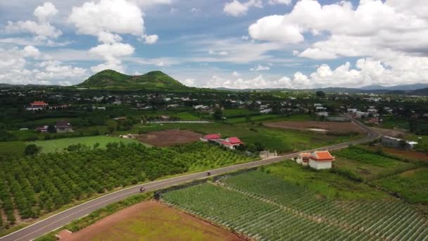 Vue aérienne du village rural avec autoroute, fermes verdoyantes et collines. — Video