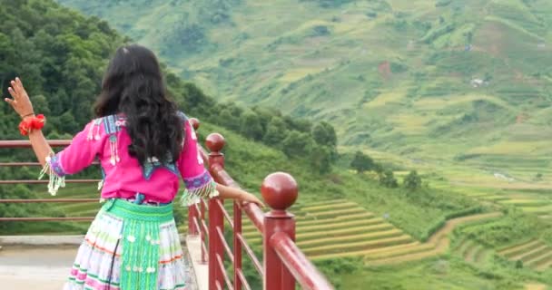 文化的なドレスのアジアの女の子は棚田の風景とビューポイント上を歩く. — ストック動画
