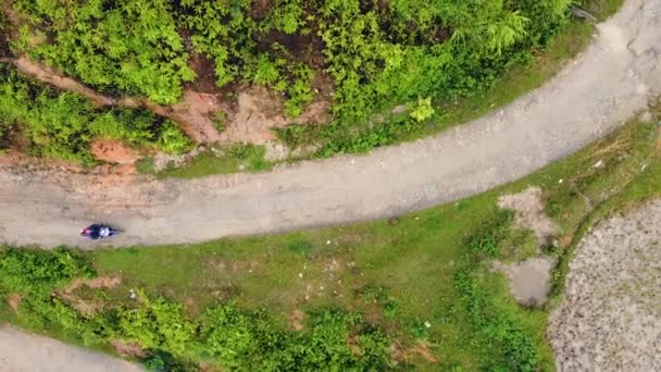Bovenaanzicht vanuit de lucht van de motorrijder op de bochtige weg in de berg. — Stockvideo
