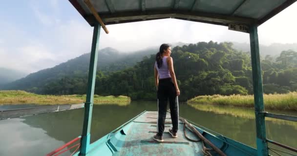 Happy young Asian woman standing on the front deck of a boat moving in the lake. — Stock Video