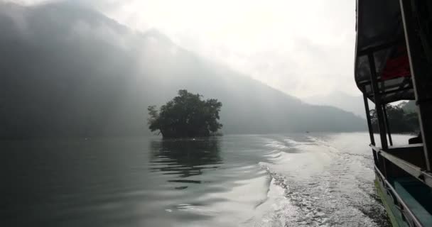 Widok boczny poruszającej się łodzi w jeziorze z naturalnym światłem tworząc tory wodne. — Wideo stockowe