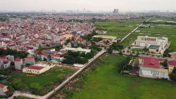 Vue aérienne sur un quartier de banlieue près d'une ville avec une autoroute et un champ vert. — Video