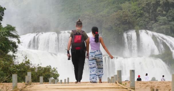 Par promenader mot det majestätiska vattenfallet i gränsen mellan Vietnam och Kina — Stockvideo