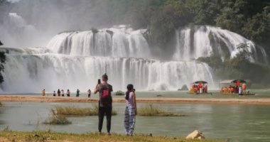 Sınırın Vietnam tarafında Ban Gioc şelalesinde duran turistler