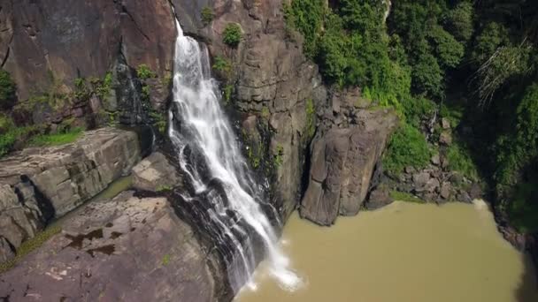 Luchtfoto van een waterval op een steile rotsachtige klif in de jungle op zomerdag. — Stockvideo
