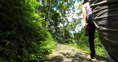 Yeşillik içinde küçük bir patikada yürüyen çift..