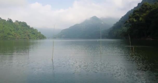 Μια όμορφη ειδυλλιακή μεγάλη λίμνη με πλούσιο πράσινο, λόφους και ομιχλώδη ουρανό. — Αρχείο Βίντεο