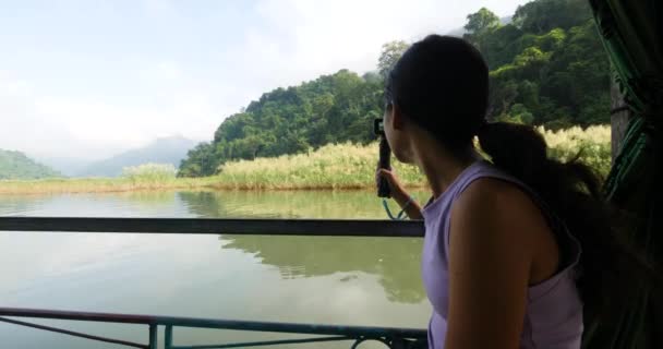 Μια νεαρή Ασιάτισσα στο σκάφος στη λίμνη με κάμερα δράσης να τραβάει βίντεο.. — Αρχείο Βίντεο