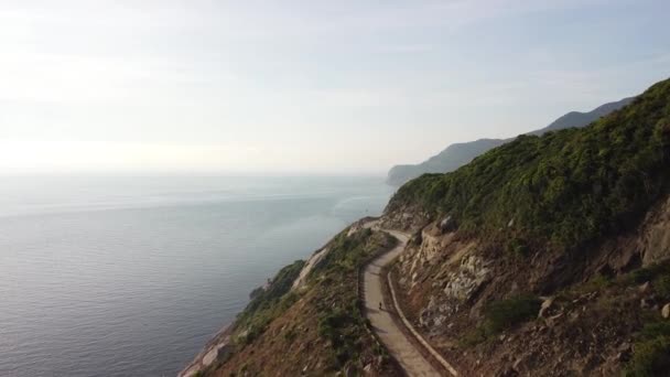 Aéreo: Vista panorâmica de uma estrada curvilínea de penhasco em uma ilha tropical no dia de verão — Vídeo de Stock