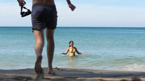 Jovem feliz e homem na praia desfrutando do mar azul intocado. — Vídeo de Stock