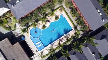 Güneşli bir günde yüzen bir adamla bir tatil köyünde havuz manzarası..