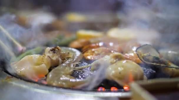 Close up view of smoking and sizzling seafoods being cooked on the grill stove. — Stock Video