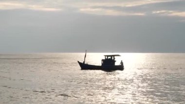 Sakin, güneşli bir öğleden sonra, sakin bir denizde yüzen bir balıkçı teknesi..