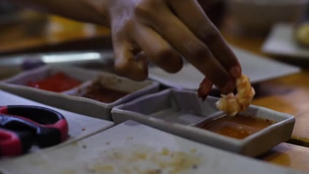 Peoples hands dipping seafoods and lemon in a sauce in the sauce plate at a cafe. — Stock Video