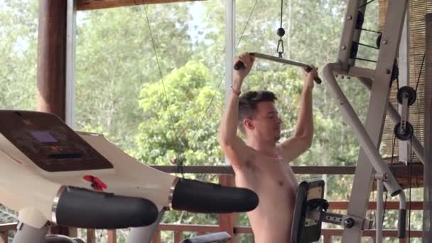 Starker kaukasischer Mann beim Hochziehen in einem Fitnessstudio auf der heimischen Terrasse. — Stockvideo