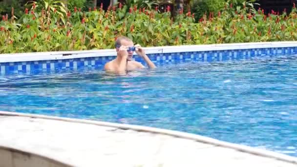 Close up tracking shot di un uomo caucasico in gogless nuoto in piscina all'aperto. — Video Stock