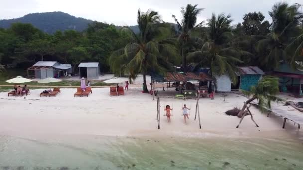 Drone fly felett fehér homokos strand trópusi szigeten turista a strandon swing — Stock videók