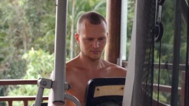 Açık hava spor salonunda egzersiz yapan genç bir beyaz adamın portresi..