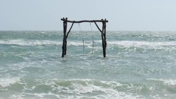 Blick auf eine hölzerne Schaukel mitten im welligen Meer. — Stockvideo