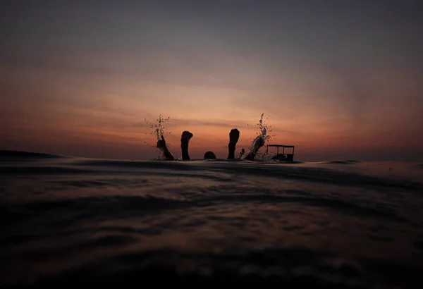 黄昏时分，一个人和一艘渔船漂浮在水面上的海景 免版税图库图片