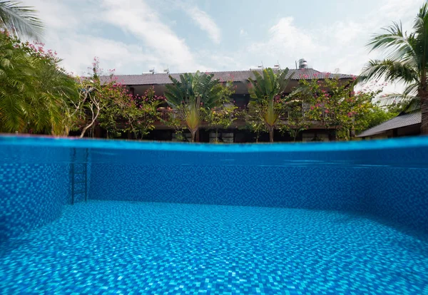 Split fotografia di piscina, alberi tropicali con villa e cielo blu. — Foto Stock