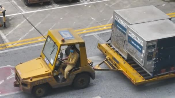 Ханой, Вьетнам - 04 03 2021: Багажный транспорт аэропорта, буксирующий тяжелые контейнеры — стоковое видео