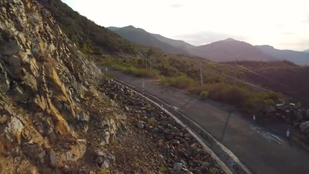 Vista panorámica aérea del borde rocoso de la montaña con la carretera vacía en el acantilado. — Vídeos de Stock