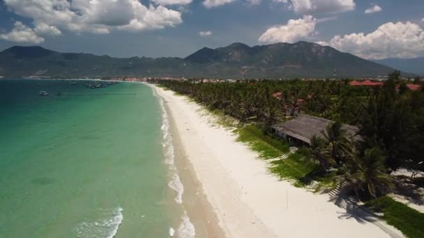 Aerial festői hosszú fehér homokos strand kilátással a városra, a hegyi tengerre és a fákra — Stock videók