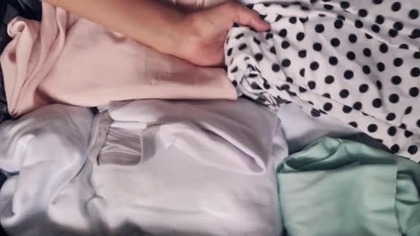 Close up on a luggage full of clothes and womans hand placing clothes and sexy lingerie. — Stock Video