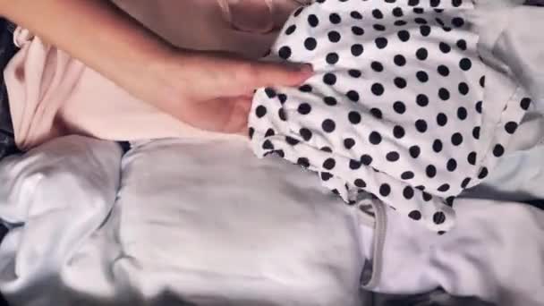Close-up van een vrouw hand het plaatsen van gevouwen kleren in de bagage en het sluiten van het.. — Stockvideo