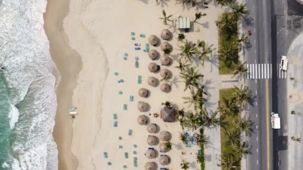 Vista aérea de uma maravilhosa praia de areia branca com ondas escovando na costa, estrada e veículos em movimento. — Vídeo de Stock