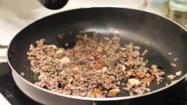 鍋に醤油を注ぐ手で調理されたひき肉を閉じます.. — ストック動画