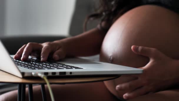 Makro skott på en arbetande gravid kvinna smeker hennes stora runda mage. — Stockvideo