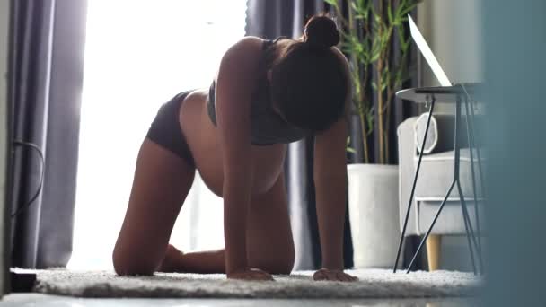 Ung gravid kvinde gør yoga positur, motion med hænder og knæ på gulvet – Stock-video